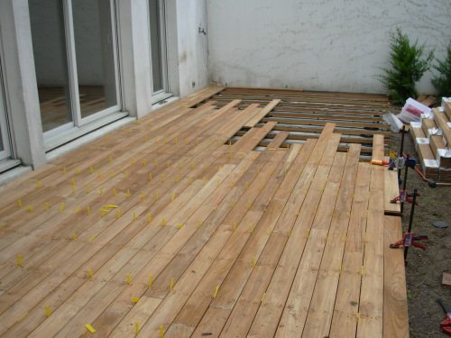 Photo de la pose de la structure sur plots et des lames de bois