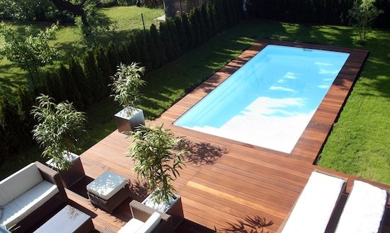 Grande piscine avec terrasse dans un jardin